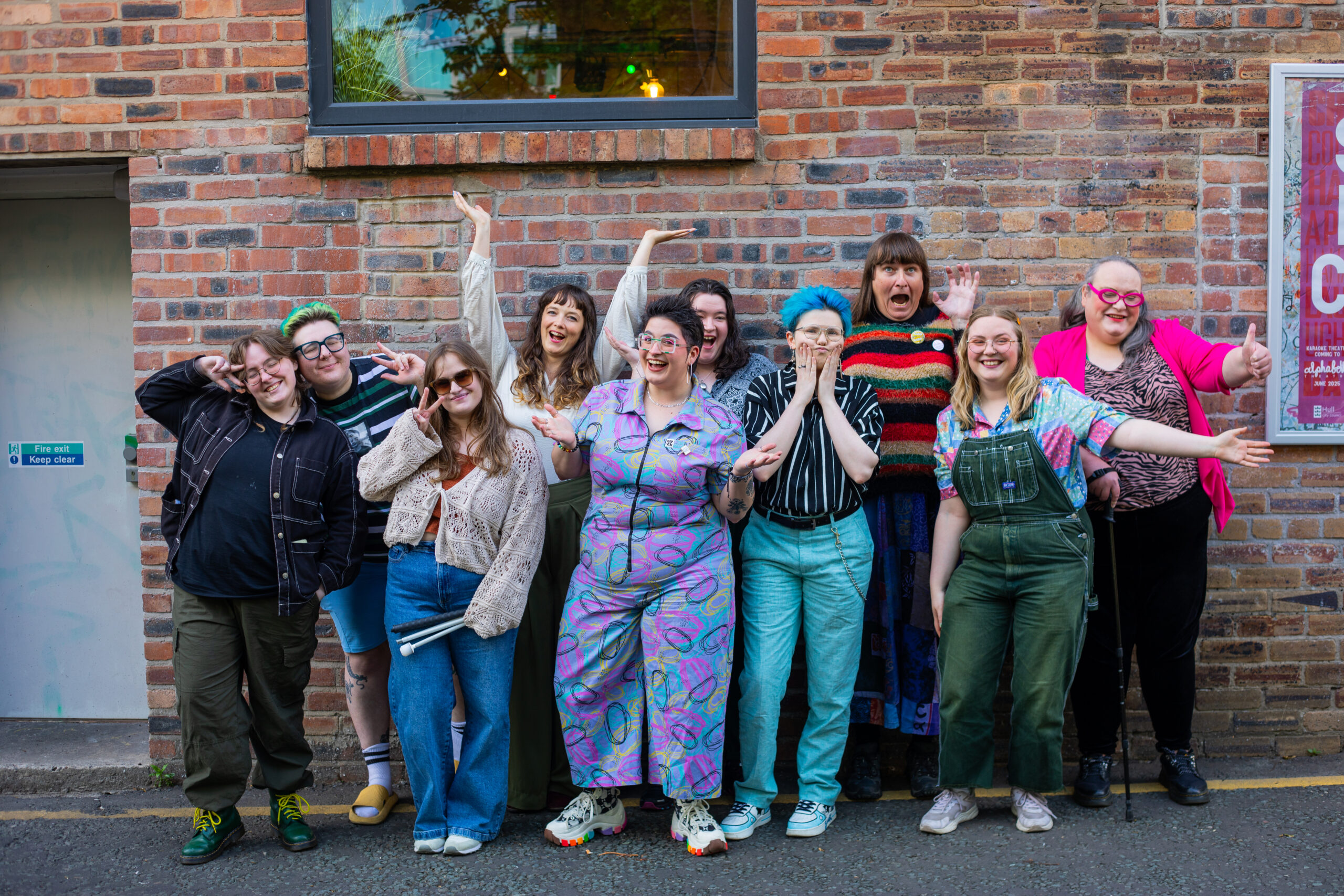 The narrative shift participants posing in  with funny faces in front of Alphabetti Theatre