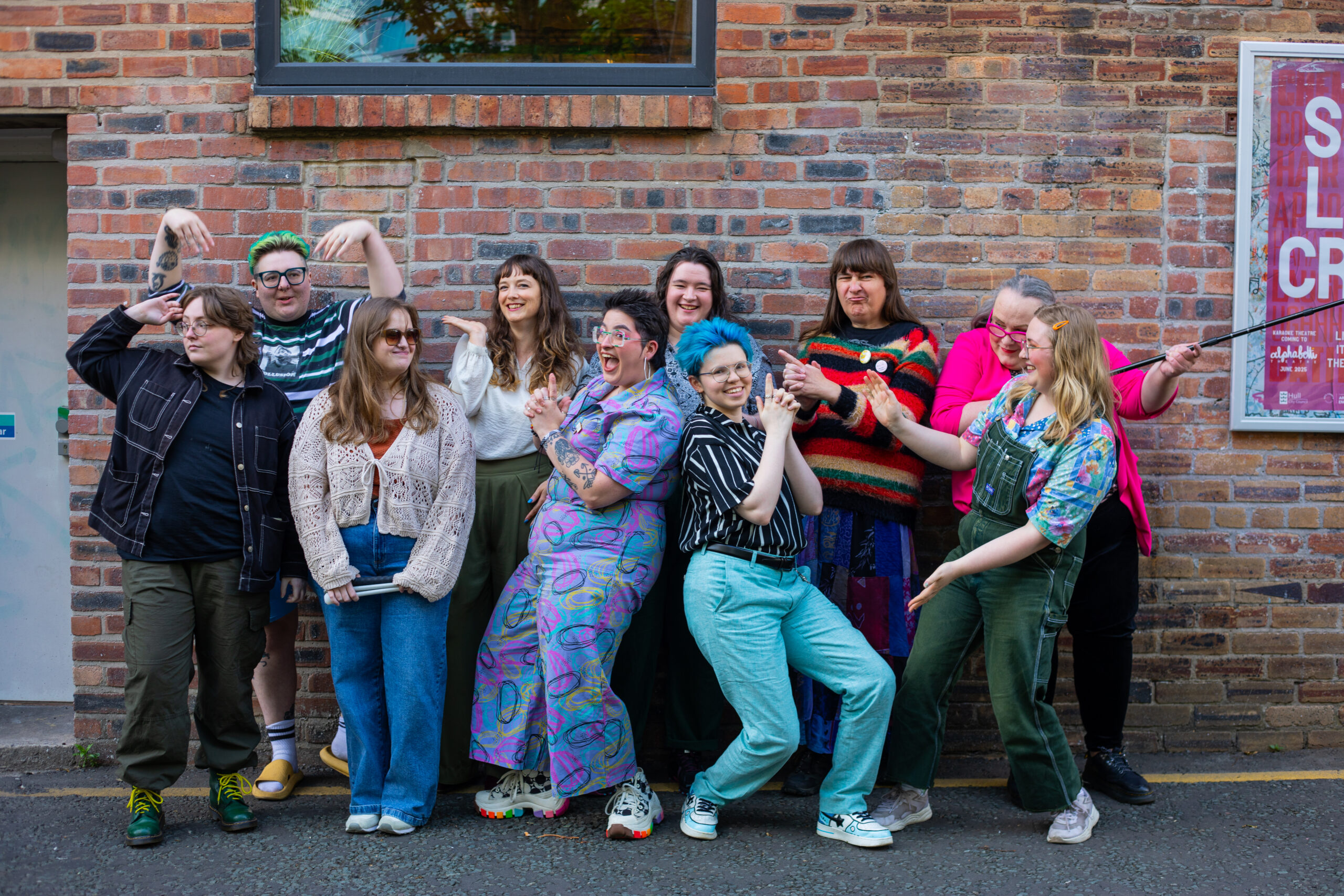the participants of narrative shift in fun poses with big smiles, outside of Alphabetti Theatre